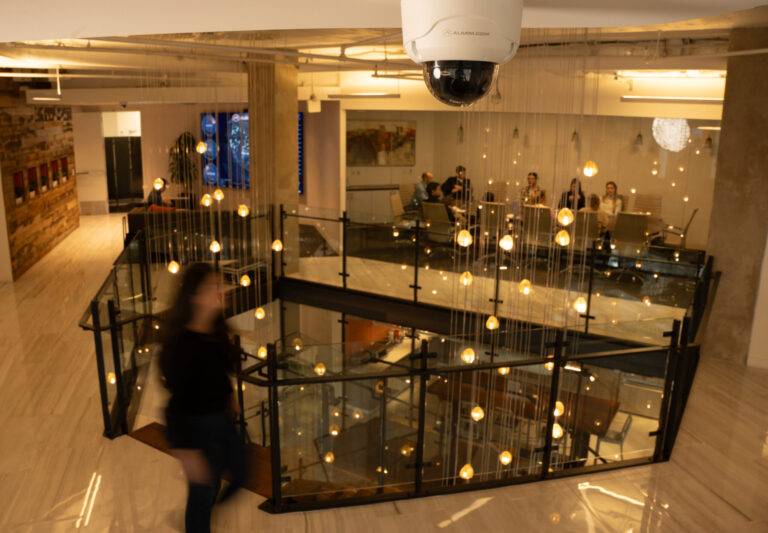 Alarm.com dome camera on the ceiling of a modern office